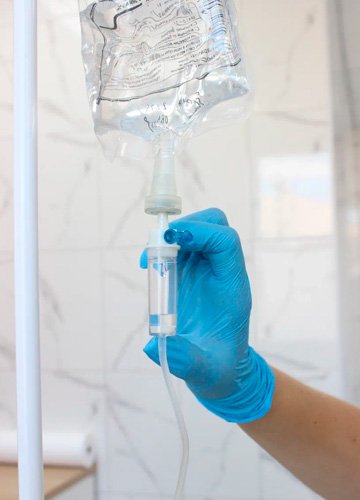 Капельница с тиоктовой кислотой Врач поправляет капельницу